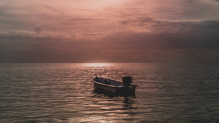 A boat on the water at sunset
