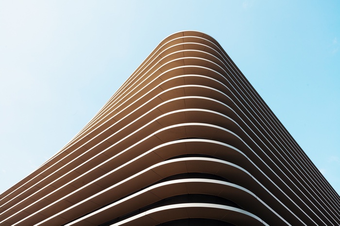 Modern building with curved facade against blue sky
