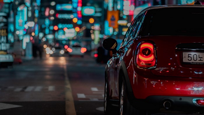 Red Mini Cooper driving at night in city