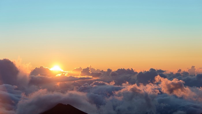 Sunrise over clouds from mountain peak