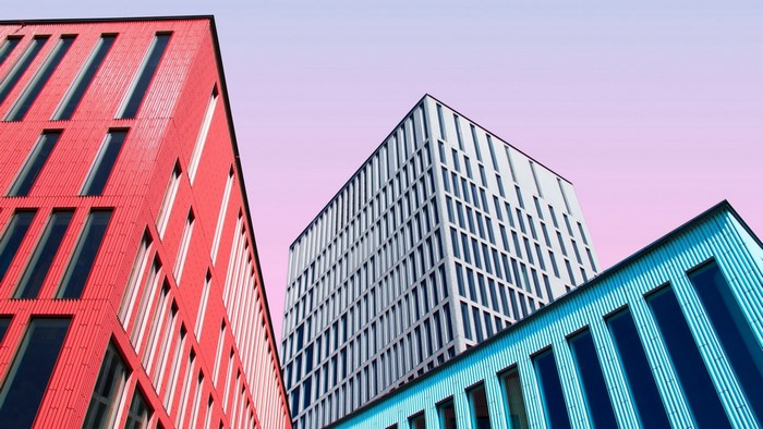 Modern buildings with colorful facades against a pink sky