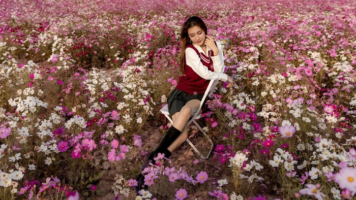Girl in a field of cosmos flowers