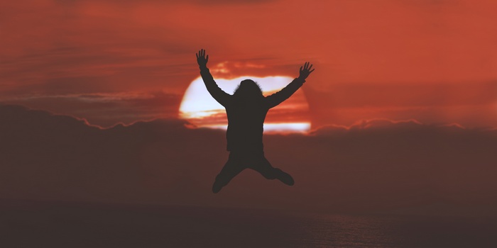 Silhouette of a person jumping at sunset
