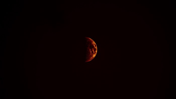 Half illuminated moon in dark sky