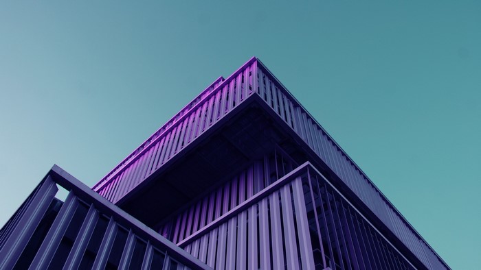 Modern building with purple lighting against a teal sky
