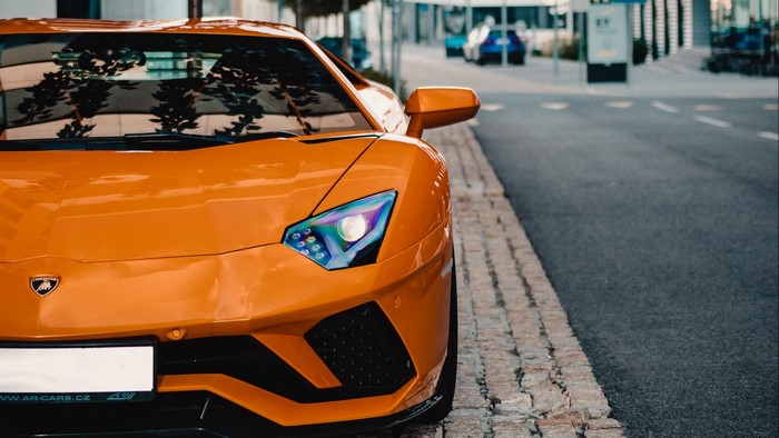 Orange Lamborghini Aventador parked on street
