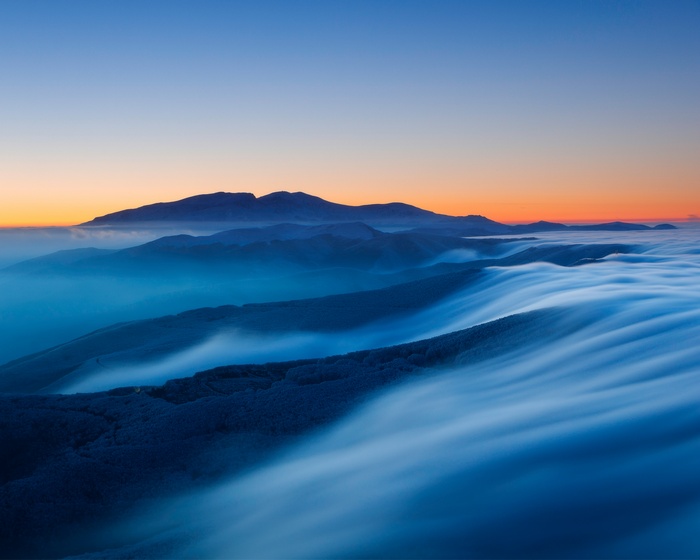 Foggy mountains at sunset with a clear sky