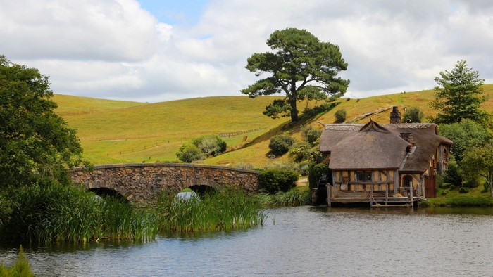 Hobbiton village with stone bridge and lake