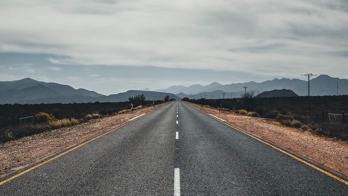 Empty highway stretching towards distant mountains