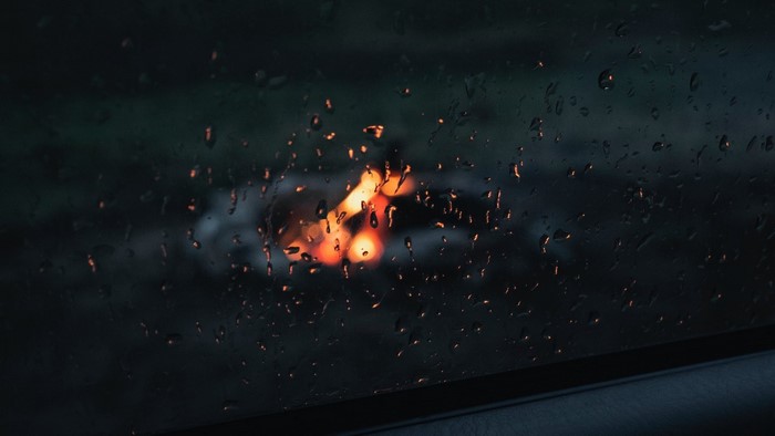 Raindrops on glass with blurred campfire lights