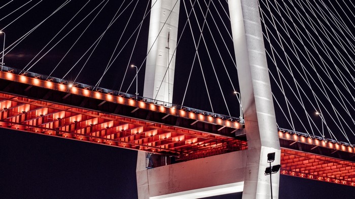 Cable-stayed bridge at night with red lights