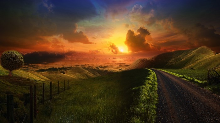 Road to sunset over rolling hills