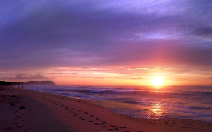 Sunset over a beach with footprints