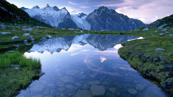 Snow-capped mountains reflected in a clear lake