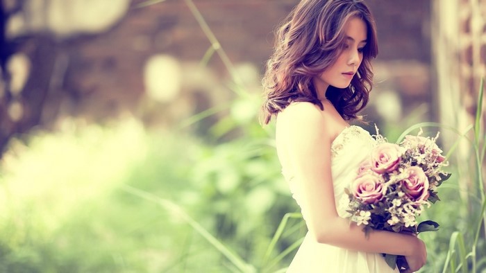 Asian bride holding a bouquet of roses
