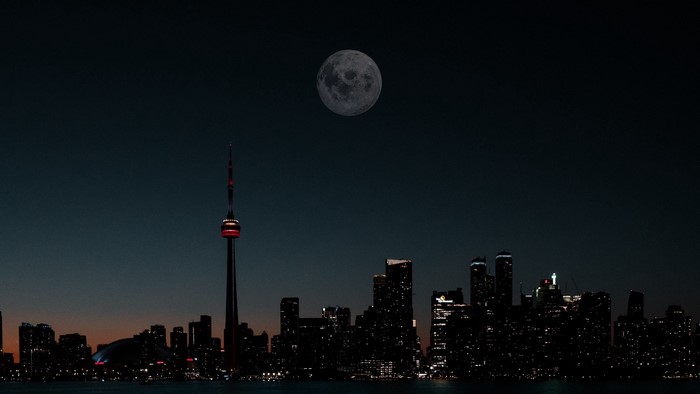 Toronto skyline with CN Tower and moon at night