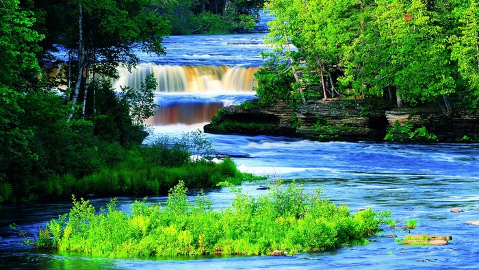 Blue waterfall surrounded by green trees
