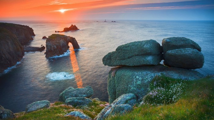 Rocky coastline with natural arch at sunset