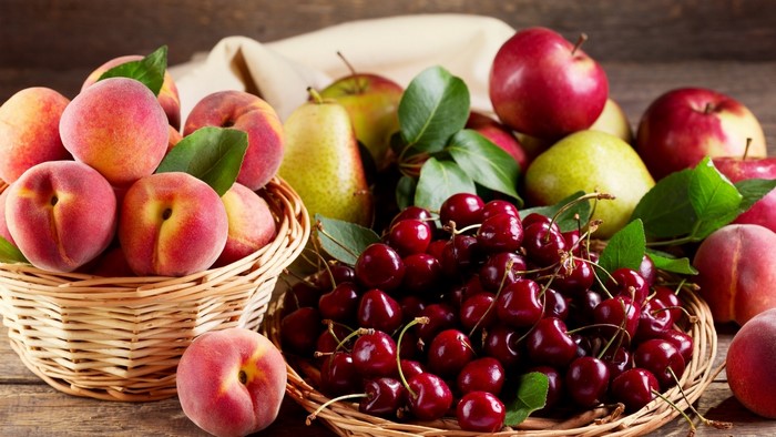 Basket of fresh fruits: peaches, cherries, apples, and pears