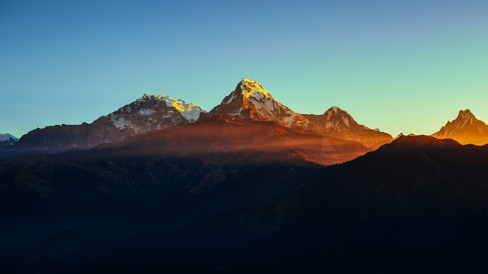 Mountain peaks at sunset with orange mist