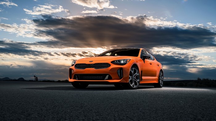 Orange Kia Stinger on Asphalt Road