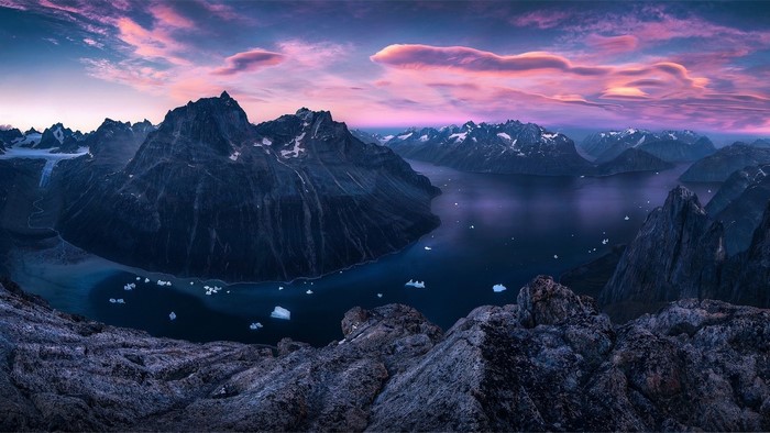 Greenland gulf with mountains and icebergs at sunset
