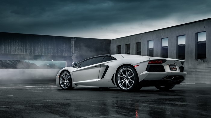 White Lamborghini Aventador parked on wet asphalt