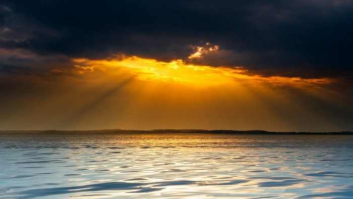Sunset over the ocean with dramatic clouds