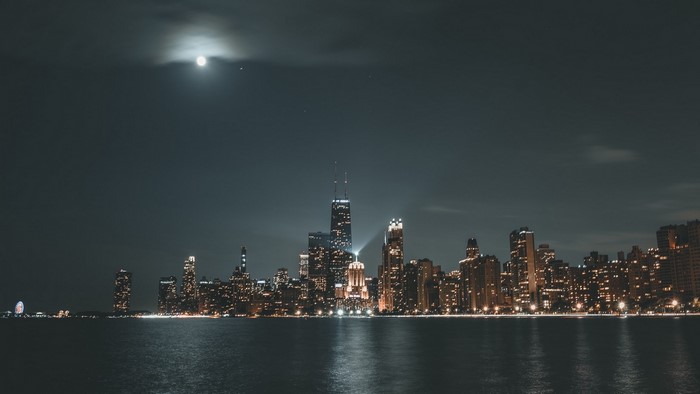 Night cityscape with moon over water