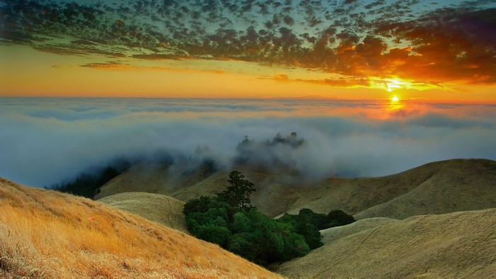 Sunset over foggy hills