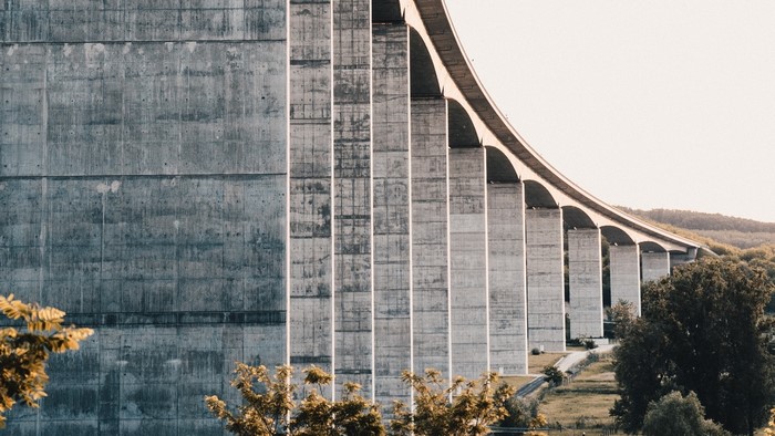 Concrete bridge with arched supports over a landscape