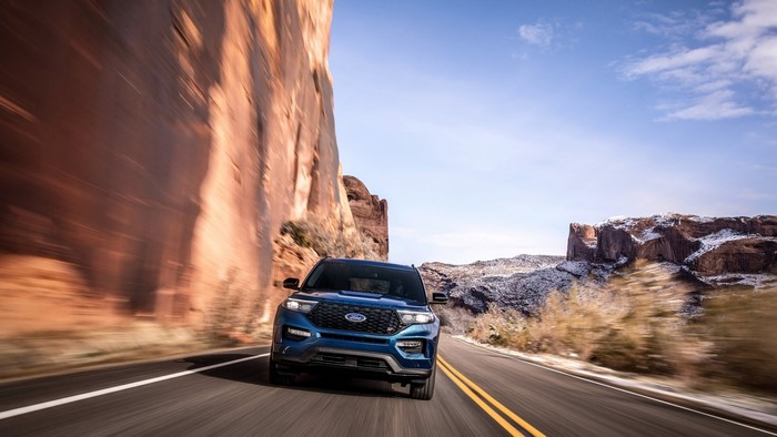 Blue Ford Explorer driving on a road in a canyon