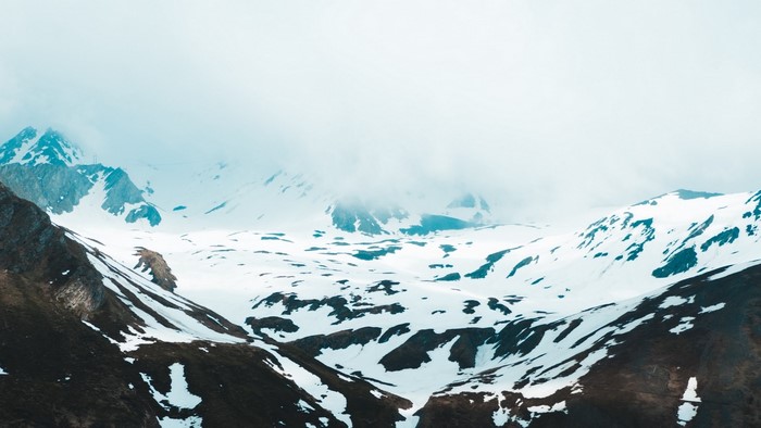 Snowy mountain slopes with clouds
