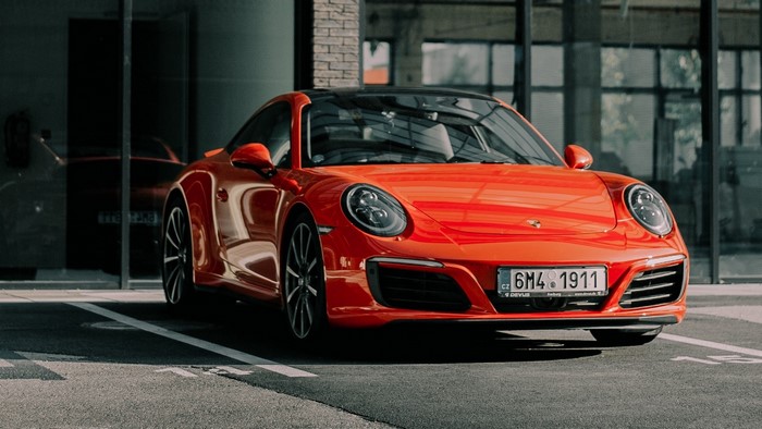Orange Porsche 911 parked in front of a building