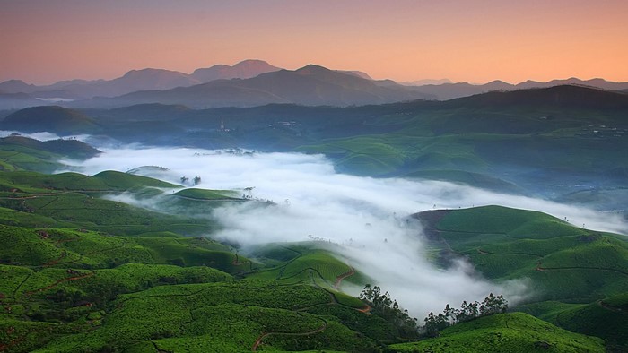 Foggy valley with rolling green hills and mountains