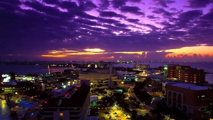 Tropical sunset over a coastal city at night