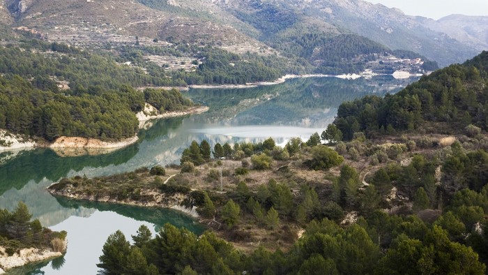 River bend surrounded by forested mountains