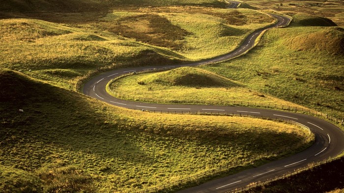 Winding road through grassy hills