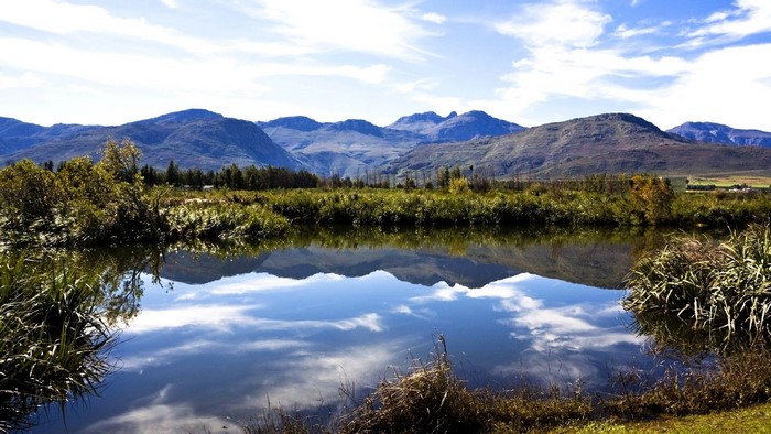 Pond reflection of mountains and sky