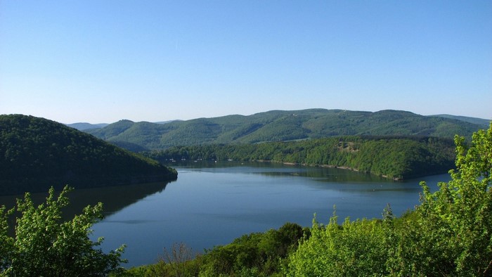 Lake and green hills under a clear blue sky