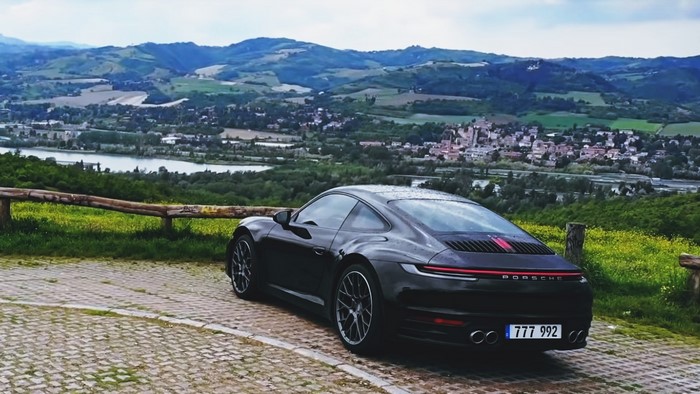 Black Porsche 911 parked with scenic view