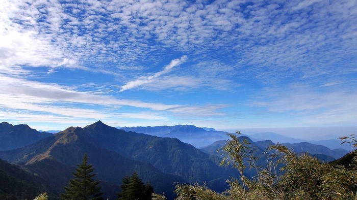 Mountains under a blue sky with scattered clouds
