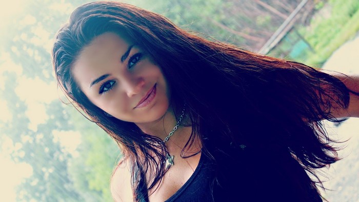 Woman with long dark hair and necklace