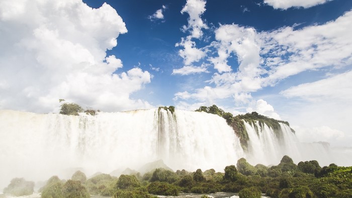 Iguazu Falls under a cloudy blue sky