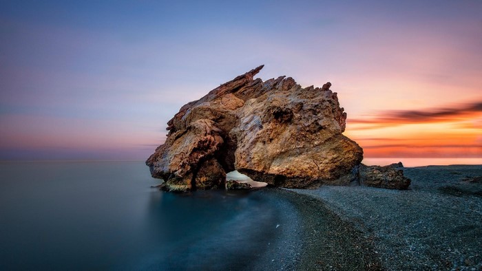 Rock formation on a beach at sunset