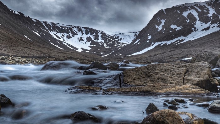 Mountain valley with a river and snow