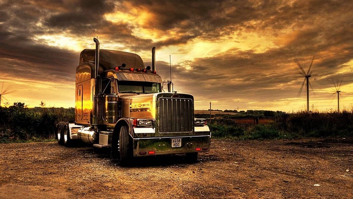Chrome Semi-Truck at Sunset with Wind Turbines