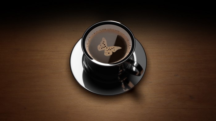 A cup of coffee with a butterfly design