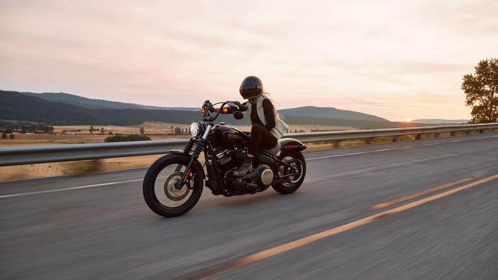 Woman riding a Harley-Davidson motorcycle at sunset