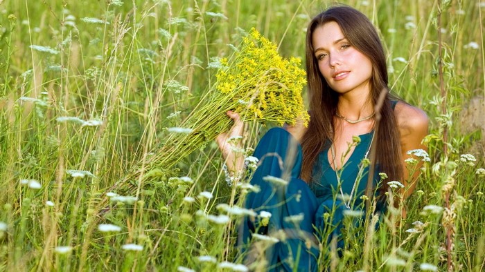 Girl with yellow flowers in a field